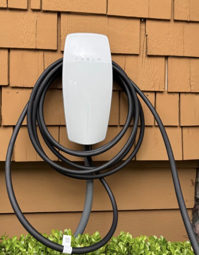 Tesla Wall Connector on cedar shingle siding with the cable coiled, Clark County WA